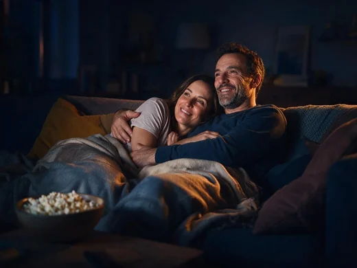 Pareja viendo una película en el sofá